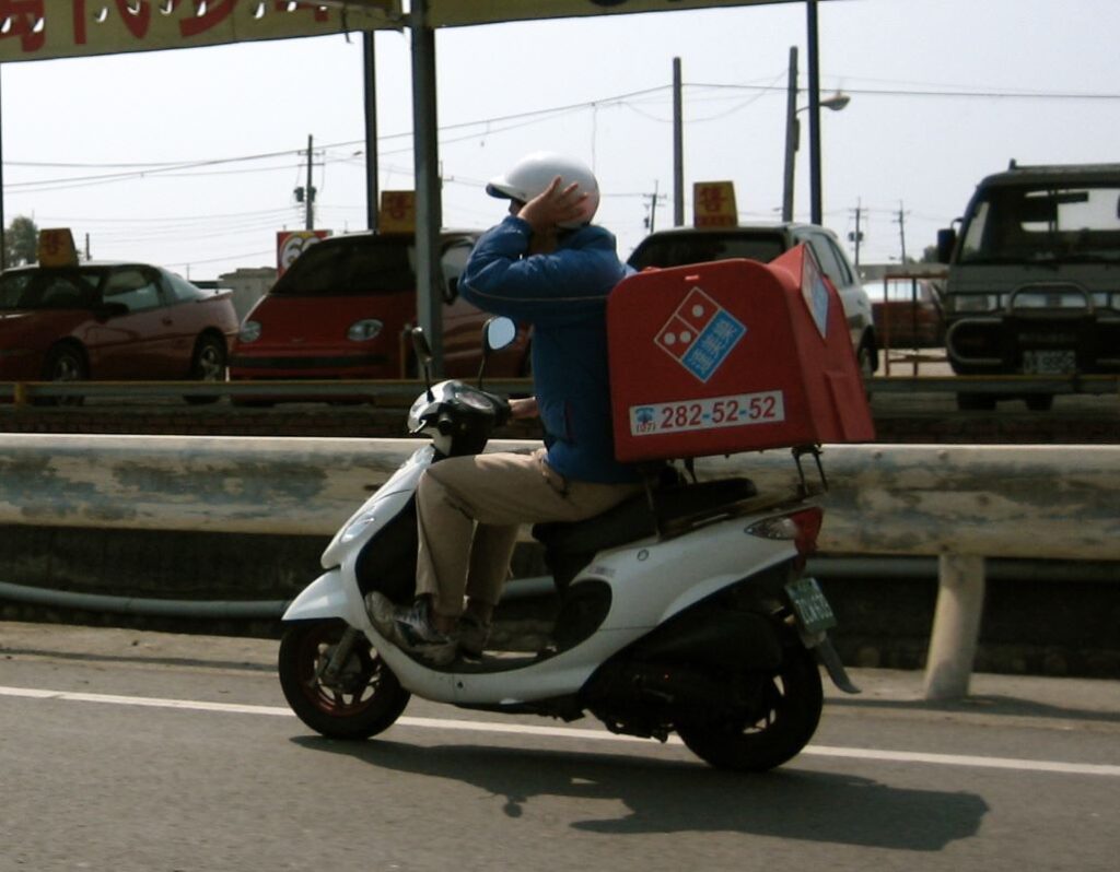 Delivery man on a two-wheeler for a pizza chain