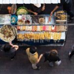 People waiting to buy street food from a roadside vendor