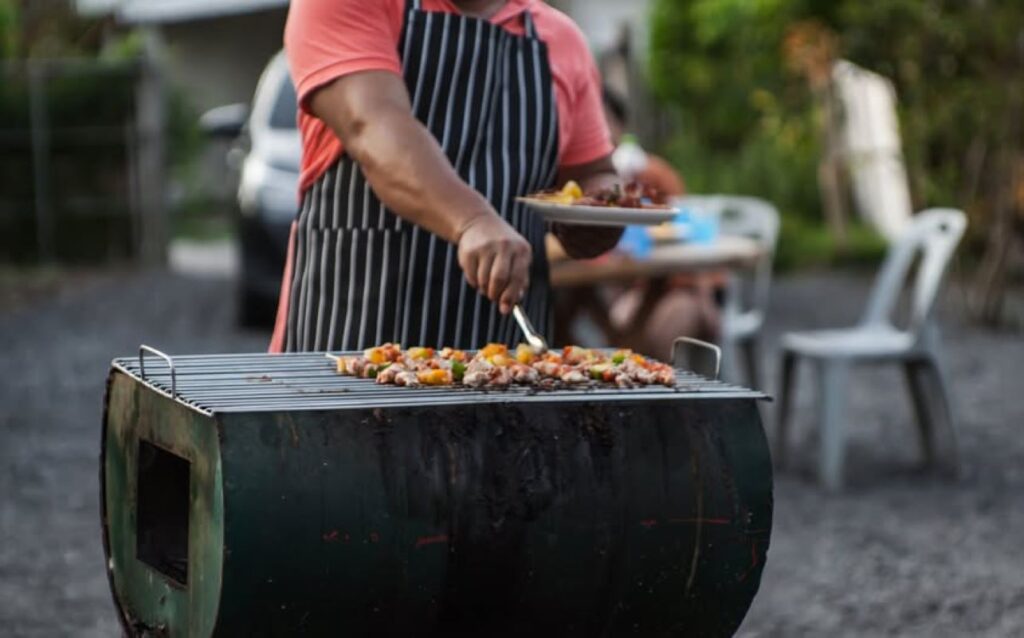 Man turning over food on a grill