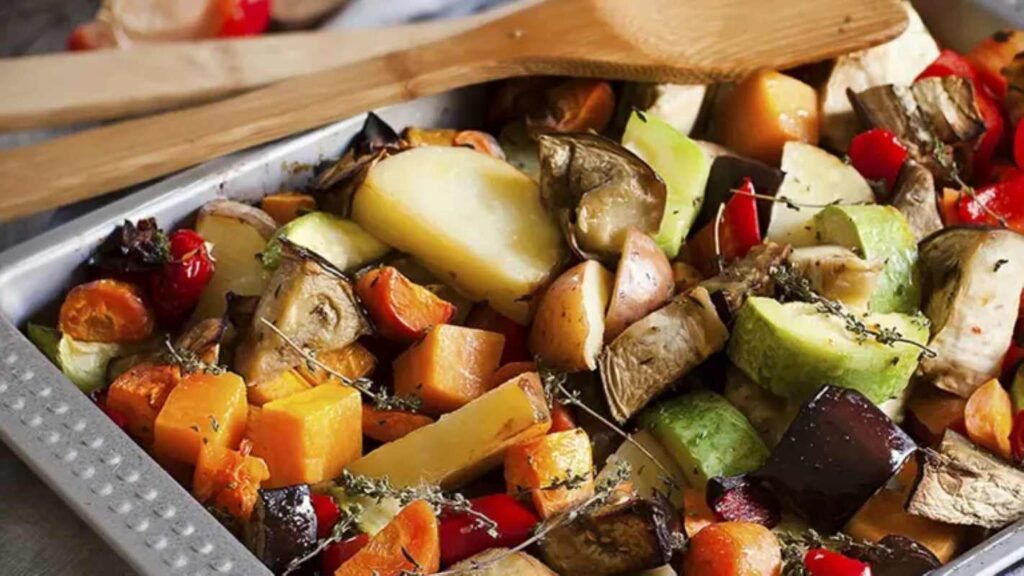 Mixed roasted vegetables with thyme in a tray. Selective focus.