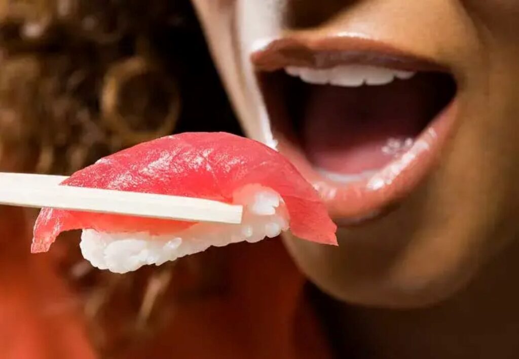 Person eating raw fish