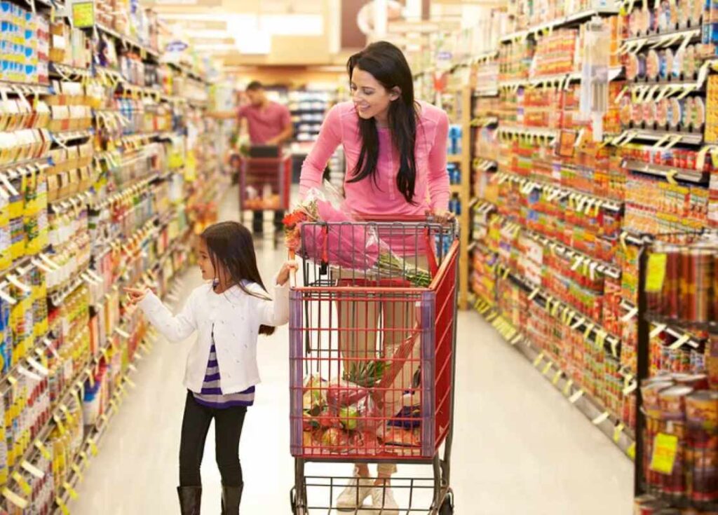 A woman and young girl walking through the aisle of a store
