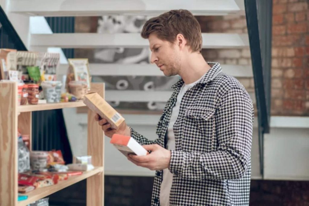 Man sideways to camera choosing food near shelves