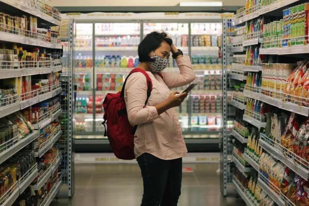 Woman standing in a shopping aisle, confused by claims on food labels
