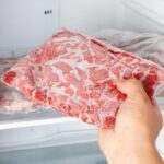 Man taking out frozen meat from the freezer
