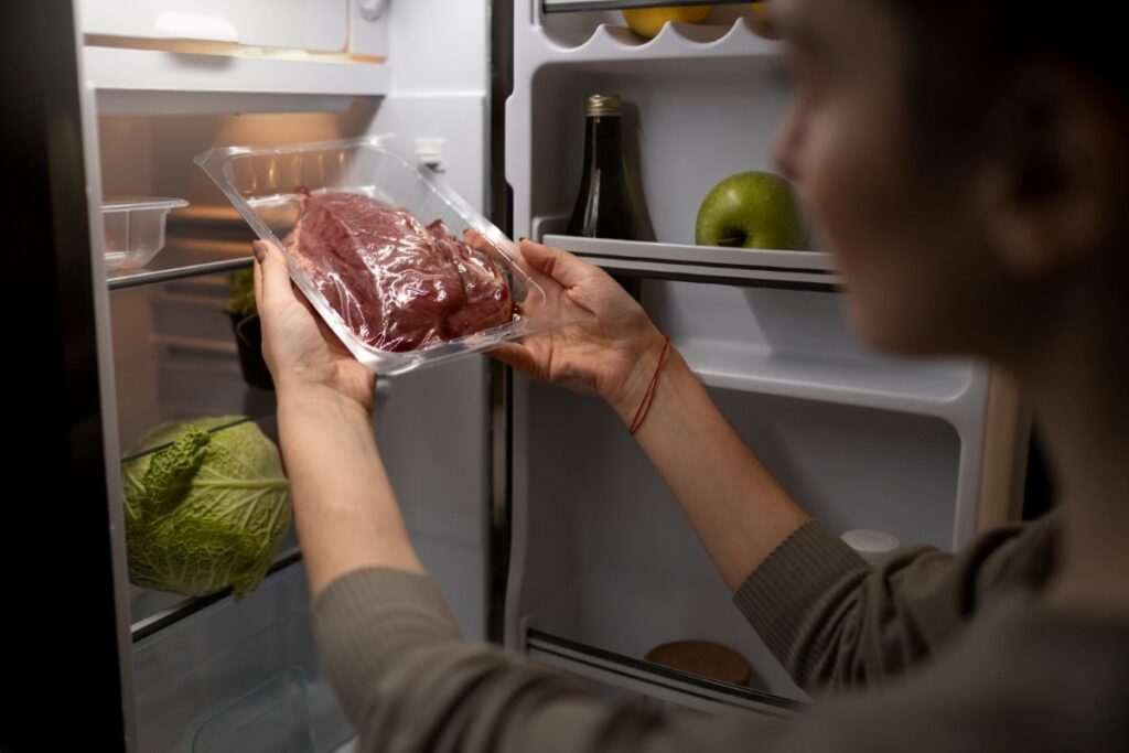 Side view of a woman holding meat