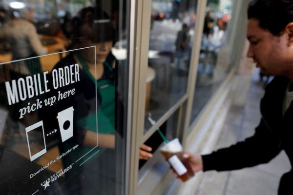 A customer picking up an order at a Starbucks pick-up only outlet