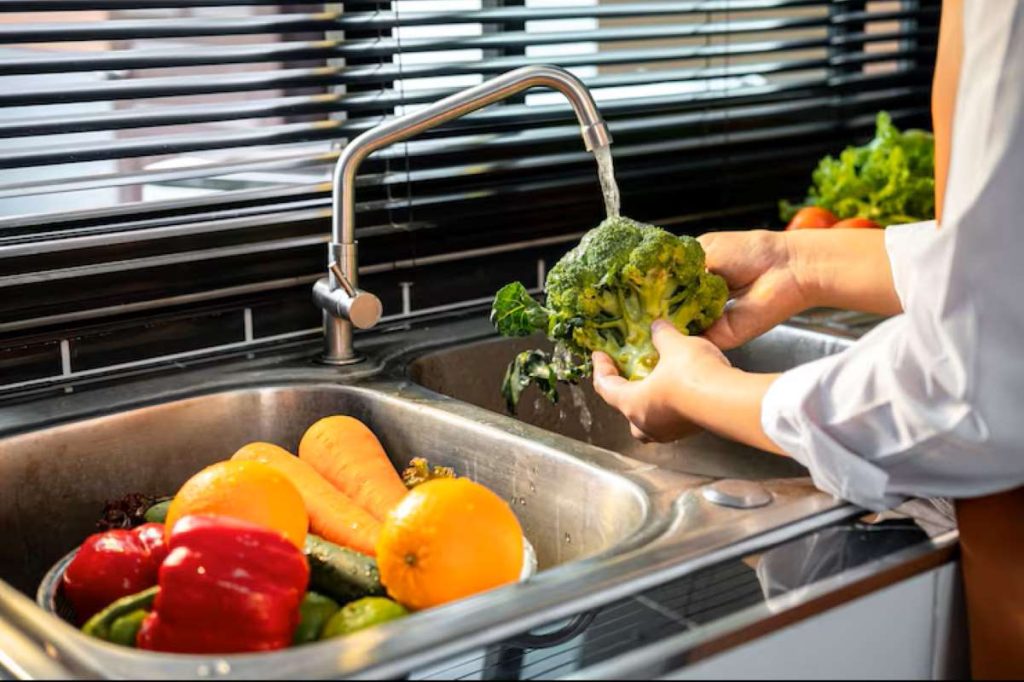 A Woman washing vegetables for preparation of vegetables