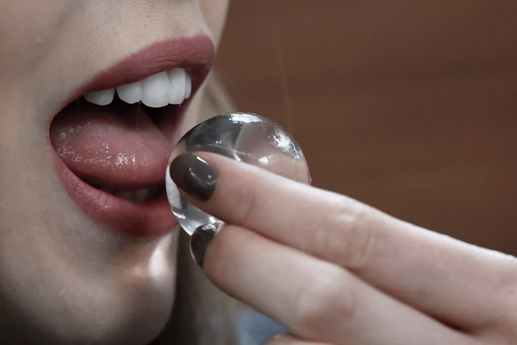 Making Edible Water Pods at Home: A Fun and Sustainable Alternative to Plastic Bottles A woman putting a seaweed water pod in her mouth