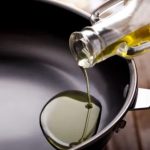 Oil being poured into a clean frying pan