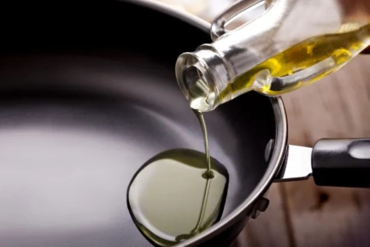 Oil being poured into a clean frying pan