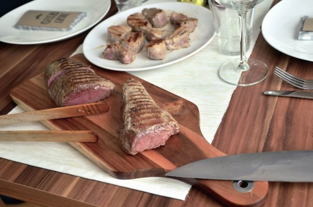 meat, cutting board, knife, food, glass, fork, plate