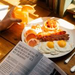 An image of someone reading a magazine over breakfast
