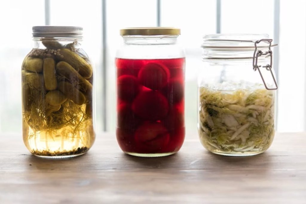 three jars filled with different types of fermented food